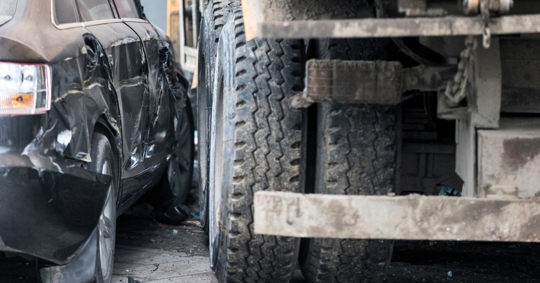 Close up of a sideswipe accident between a large truck and a car.